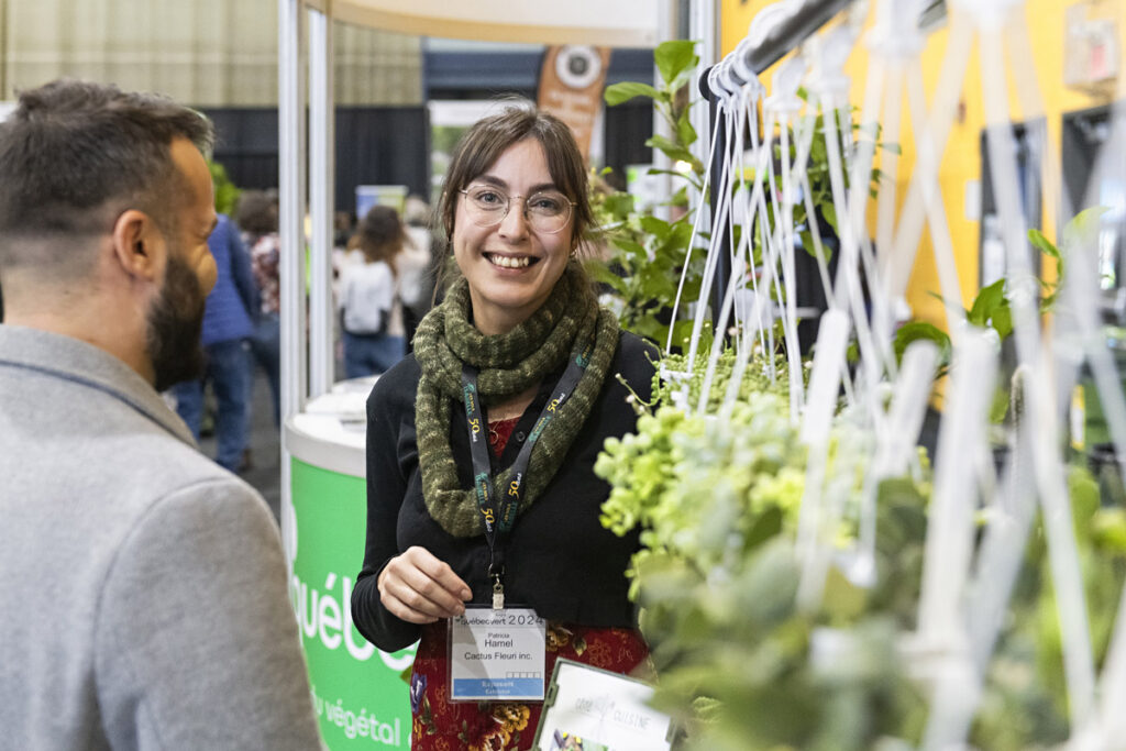 Beau sourire d'une exposante entourée de fleurs